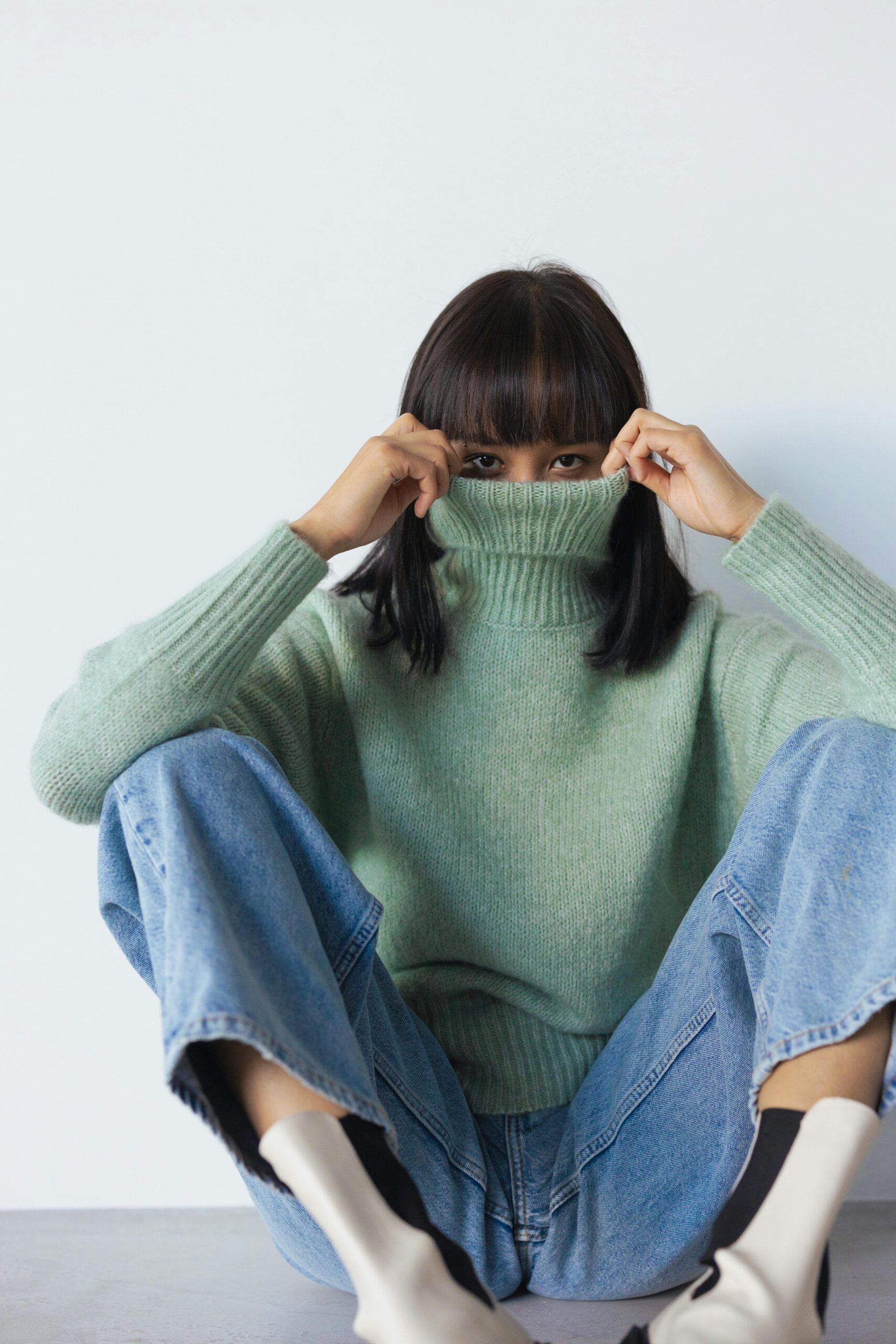 Person Covering Her Face With Knitted Turtleneck Long Sleeves